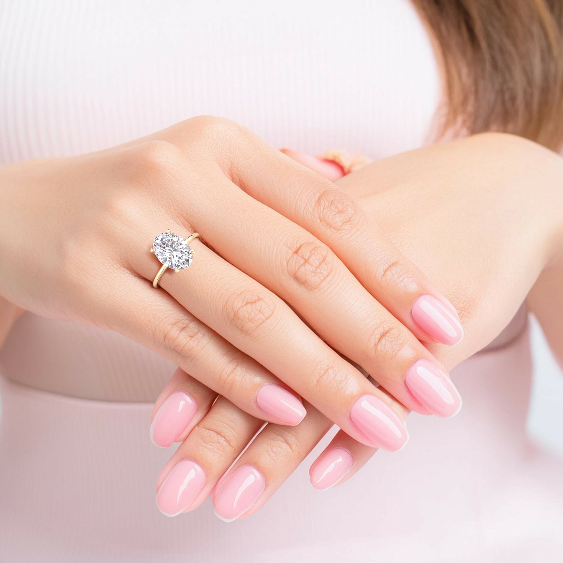 Oval diamond engagement ring in 14K or 18K gold, worn on a model’s finger, radiating timeless elegance and lustrous shine.|
#14KRecycledYellowGold 
#18KRecycledYellowGold