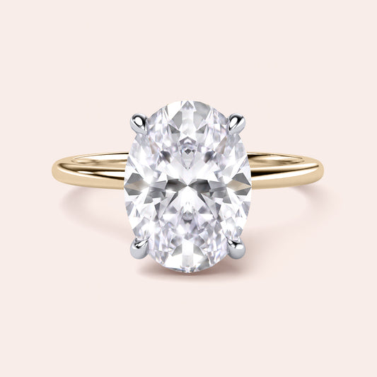 Two-tone 14K yellow and white gold oval diamond ring with secret halo, perfect for elegant engagements.