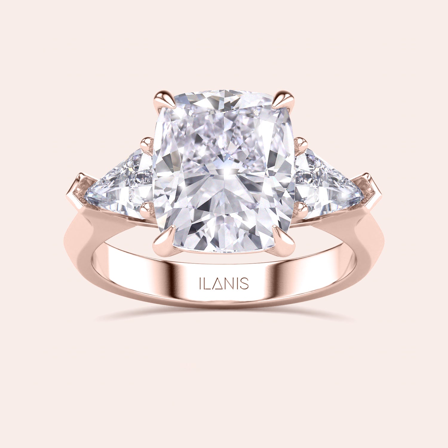 Detailed frontal close-up of elegant cushion-cut diamond ring set in a in a three stone setting with shield side stones rose gold band | 
#14KRecycledRoseGold #18KRecycledRoseGold