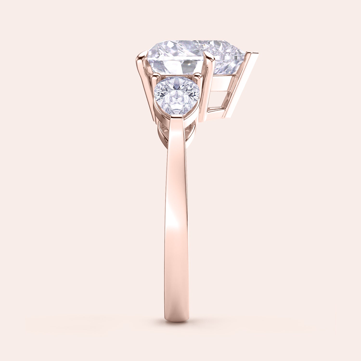 Side view of a rose gold heart-shaped diamond engagement ring, showcasing its prong settings and shimmering teardrop side stones. | #14KRecycledRoseGold #18KRecycledRoseGold