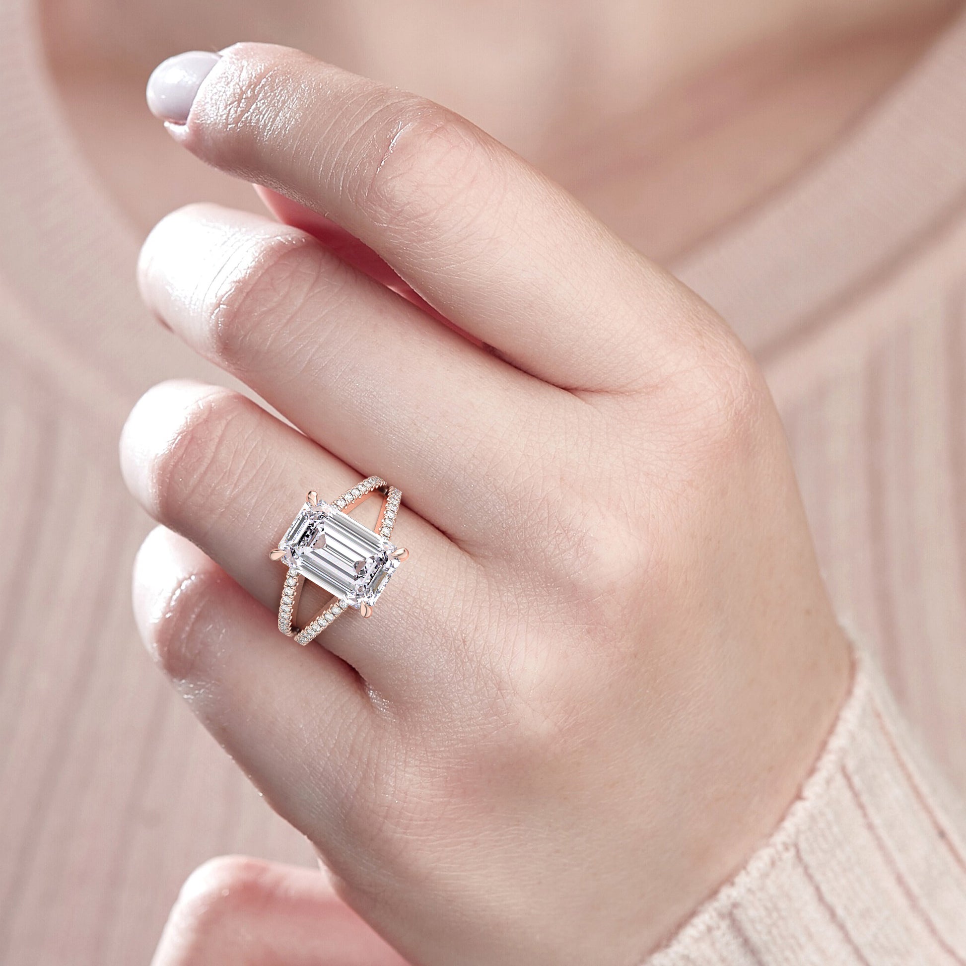 Elegant emerald cut diamond ring in 14K rose gold with a triple row diamond shank, worn on a model's hand.|
#14KRecycledRoseGold
#18KRecycledRoseGold