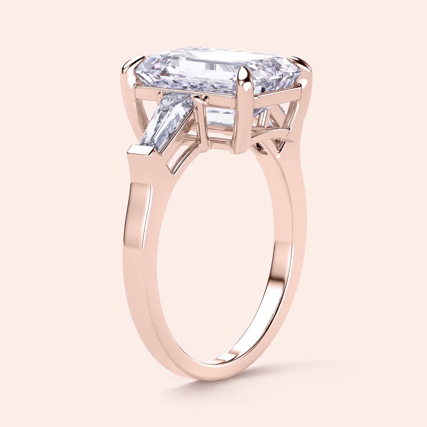 Elegant rose gold engagement ring featuring an emerald-cut diamond and tapered baguette side stones in 14K or 18K gold.|
#14KRecycledRoseGold
#18KRecycledRoseGold