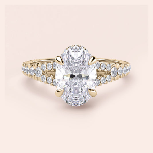 Elegant 14K gold solo engagement ring featuring an oval-cut diamond with a split shank and round diamonds.