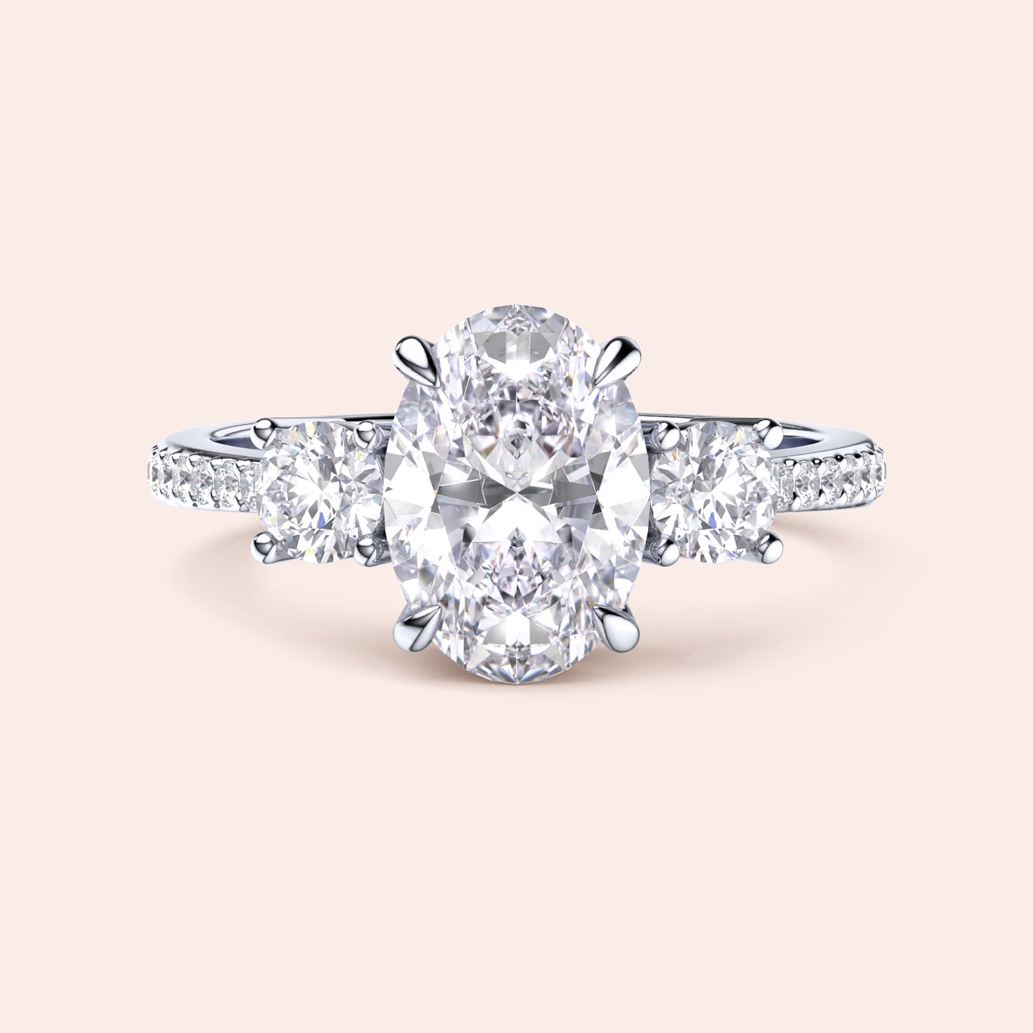 Elegant three-stone engagement ring in 14K/18K gold or platinum, featuring an oval diamond and sparkling side stones.|
#14KRecycledWhiteGold
#18KRecycledWhiteGold
#Platinum