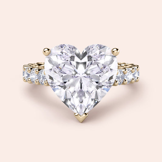 Heart-shaped diamond ring in 14K yellow gold with hidden halo and side diamonds, perfect for engagements or special occasions.