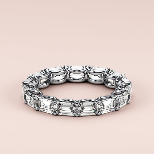 Elegant emerald-cut diamond eternity wedding band in 14K or 18K white gold or platinum, showcasing timeless luxury and intricate design.