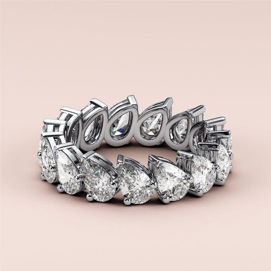 Elegant eternity wedding band featuring pear-shaped diamonds set in 14K or 18K gold or platinum, with a modern design.
