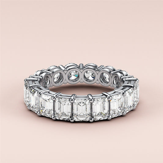 Elegant 14K white gold eternity band featuring emerald-cut and round diamonds, perfect for weddings and special occasions.