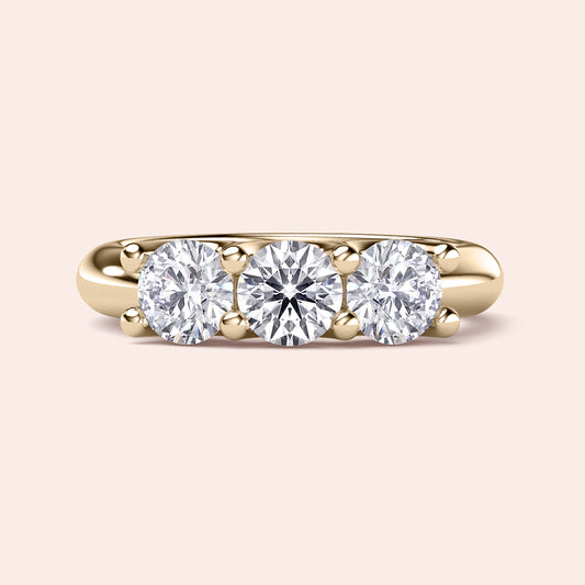 Three-stone engagement ring featuring round diamonds in a yellow gold band, available in 14K, 18K, or platinum wedding band styles.