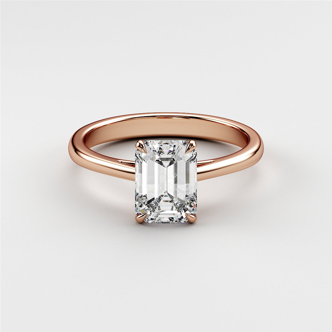 Emerald cut diamond engagement ring in 14K or 18K rose gold, elegant solitaire design on a plain background, perfect for engagements.|
#14KRecycledRoseGold
#18KRecycledRoseGold
