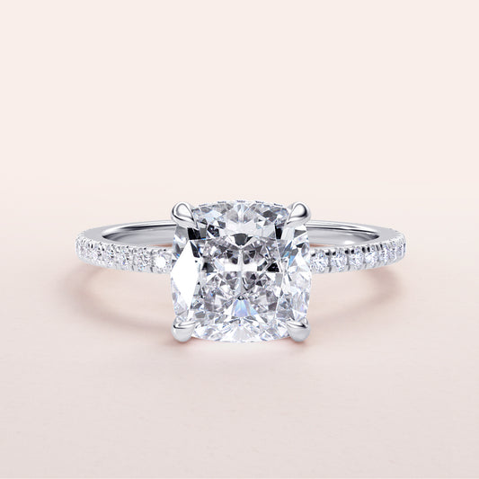 Cushion-cut diamond engagement ring with pave band in 14K or 18K white gold, perfect for a timeless proposal.