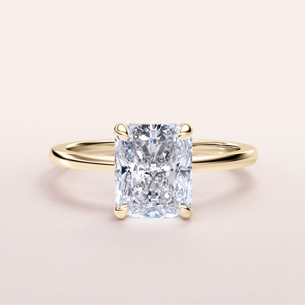Radiant cut diamond ring in 14K or 18K yellow gold, elegantly set in a hidden halo design, on a plain background.|
#14KRecycledYellowGold
#18KRecycledYellowGold
