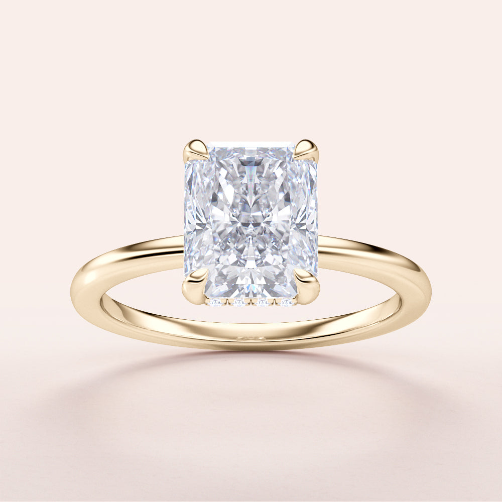 Radiant-cut diamond engagement ring in 14K or 18K gold, showcasing hidden halo design, on light beige background.|
#14KRecycledYellowGold
#18KRecycledYellowGold