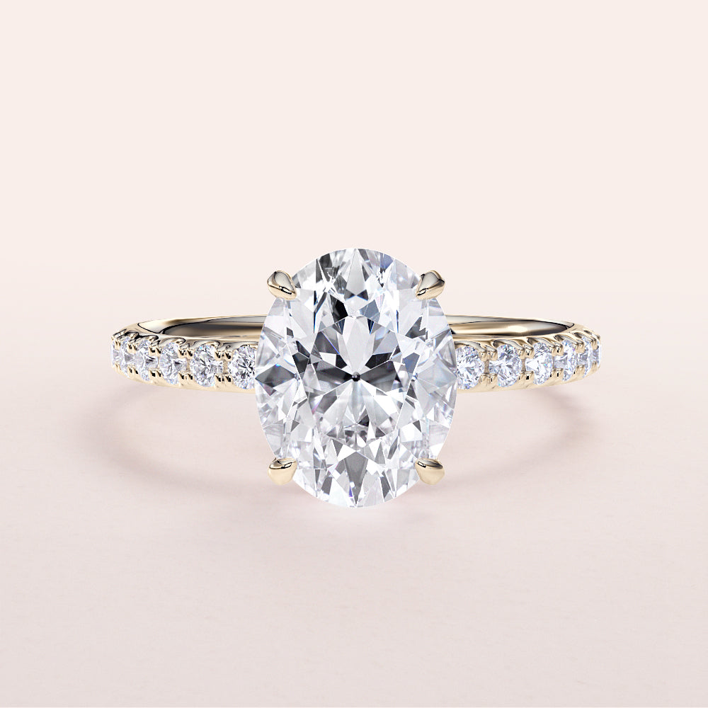 Elegant oval diamond engagement ring in 14K gold, set in a pave band, showcasing a hidden halo and stunning prong accents.|
#14KRecycledYellowGold
#18KRecycledYellowGold