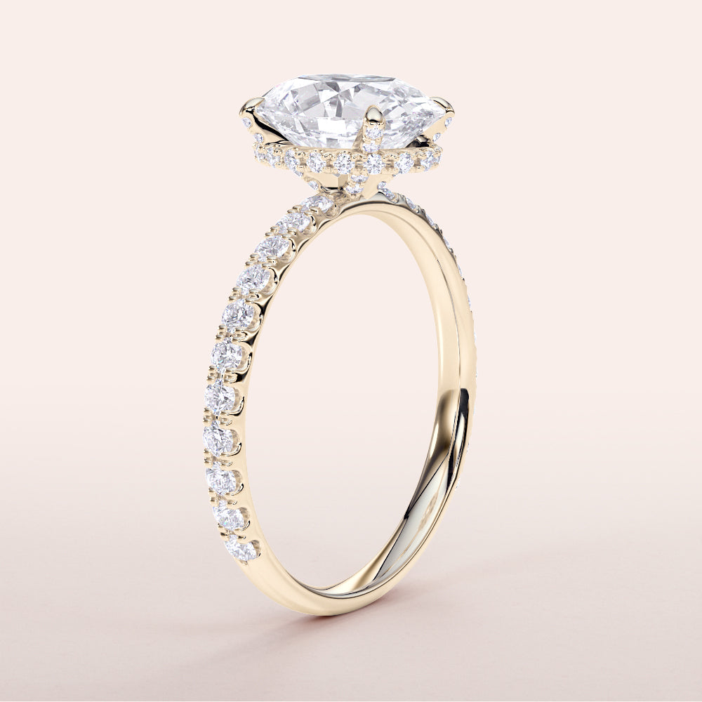 14K yellow gold engagement ring featuring an oval wrapped hidden halo, prong accents, and pave-set diamond band, side view.
#14KRecycledYellowGold
#18KRecycledYellowGold