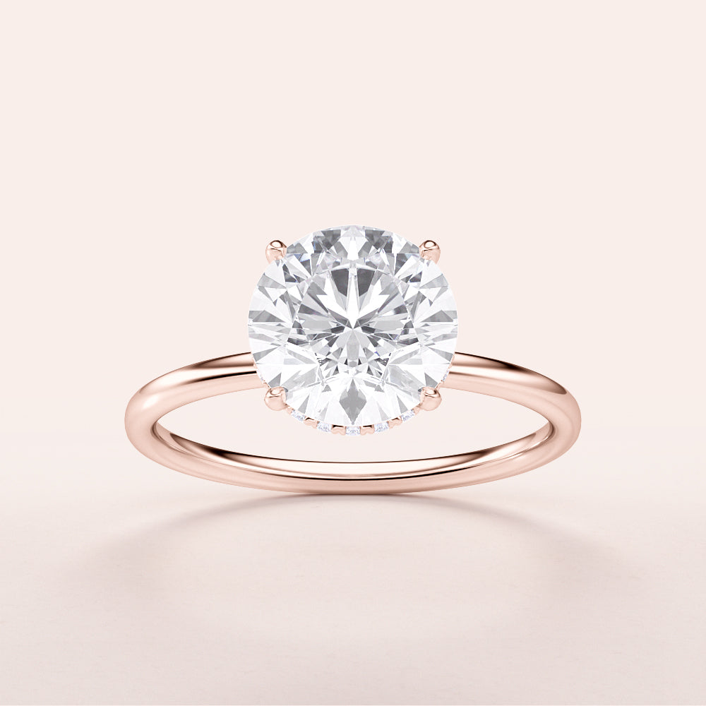 Elegant rose gold 14K wrapped hidden halo engagement ring featuring a round-cut diamond on a sleek plain band.|
#14KRecycledRoseGold
#18KRecycledRoseGold