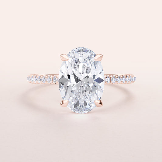 Exquisite rose gold 14K or 18K oval diamond engagement ring with diamond-studded band and hidden halo design.