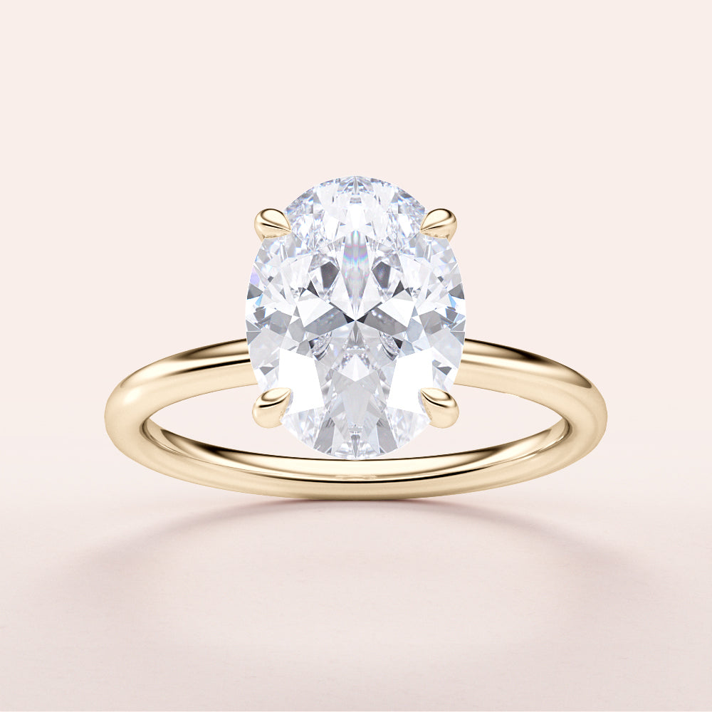 Elegant 14K/18K yellow gold engagement ring featuring an oval diamond center stone on a plain light background.|
#14KRecycledYellowGold
#18KRecycledYellowGold