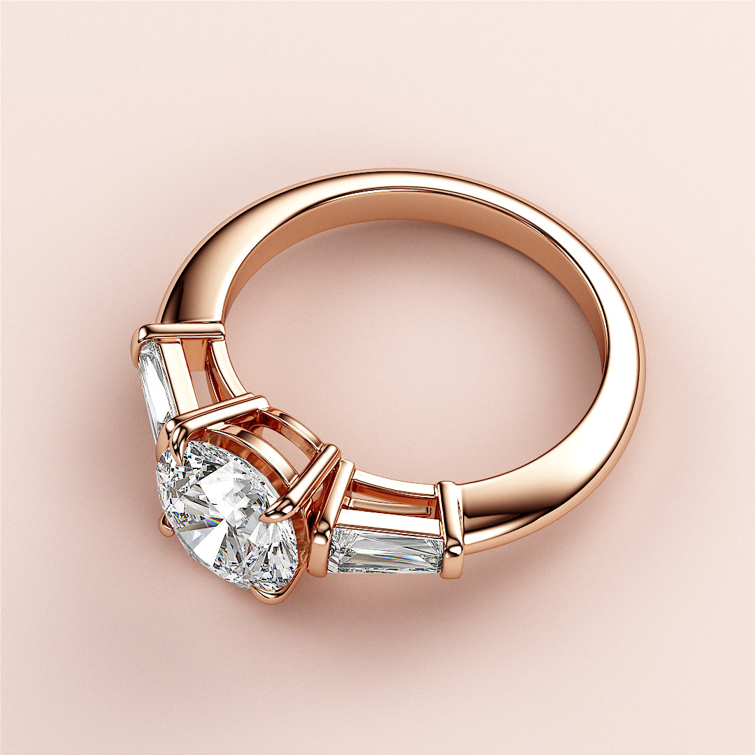 Elegant 14K rose gold engagement ring with oval-cut diamond and tapered baguette accents on a minimalist background.|
#14KRecycledRoseGold
#18KRecycledRoseGold