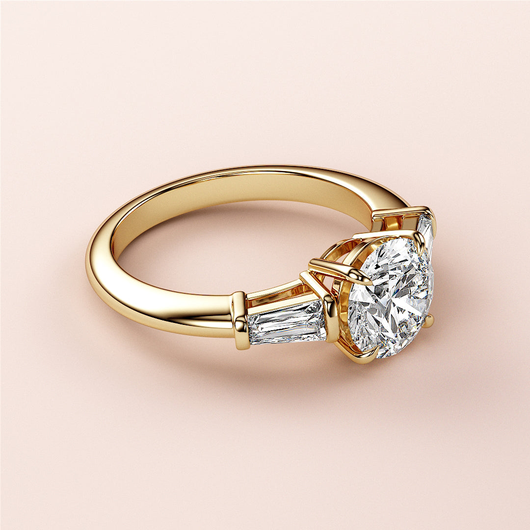 "Elegant round-cut diamond engagement ring in 14K or 18K yellow gold or platinum, featuring tapered baguette side diamonds."|
#14KRecycledYellowGold
#18KRecycledYellowGold