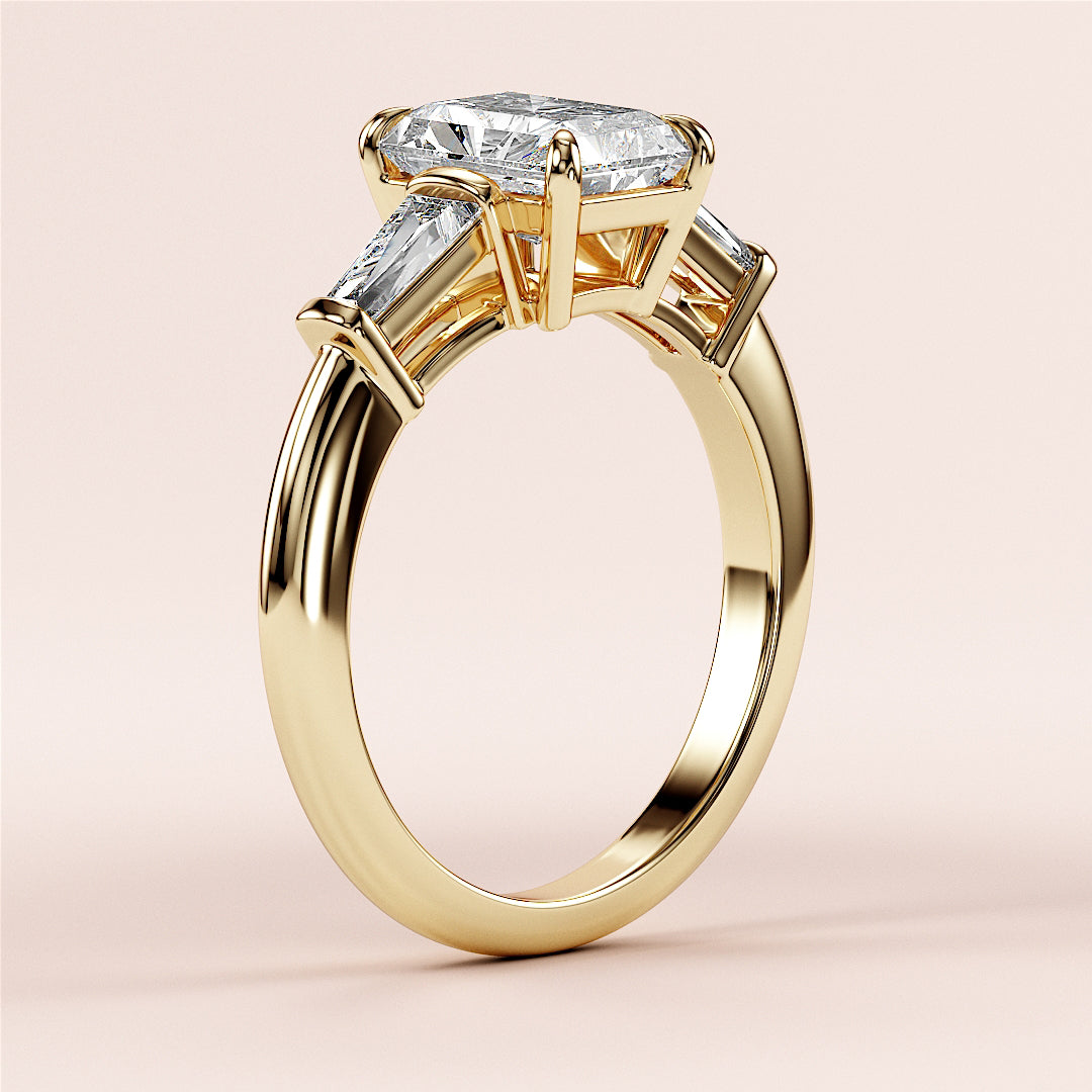 Elegant 14K or 18K yellow gold engagement ring featuring a radiant three-stone design with tapered baguettes for timeless beauty.|
#14KRecycledYellowGold
#18KRecycledYellowGold