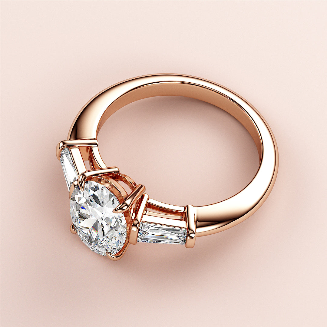 Stunning 14K or 18K rose gold engagement ring with oval three-stone design and tapered baguette diamonds, perfect for proposals.|
#14KRecycledRoseGold
#18KRecycledRoseGold