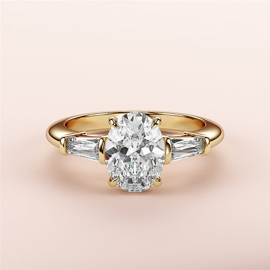 Elegant yellow gold engagement ring with an oval diamond and tapered baguettes, available in 14K, 18K, and platinum settings.