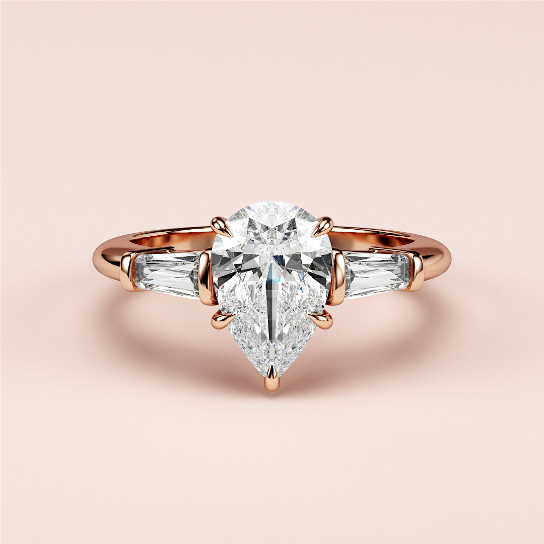 Elegant rose gold engagement ring featuring pear-shaped diamond and tapered baguette-cut side stones in 14K/18K or platinum setting.|
#14KRecycledRoseGold
#18KRecycledRoseGold