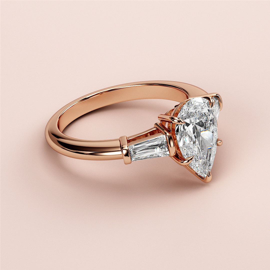 Rose gold engagement ring featuring a trillion-cut diamond center and tapered baguette diamonds, available in 14K, 18K, or platinum.|
#14KRecycledRoseGold
#18KRecycledRoseGold