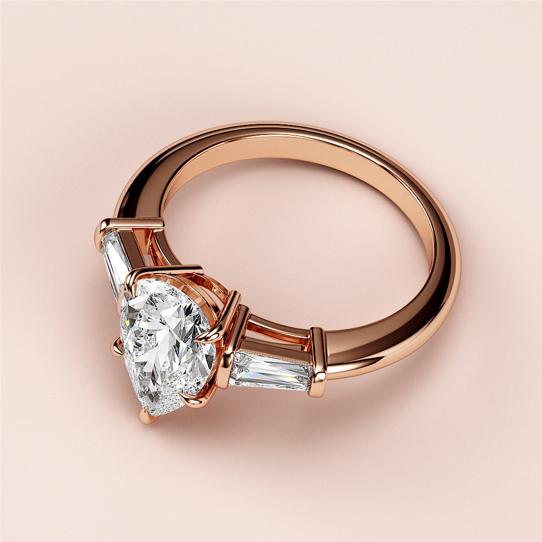 Elegant solitaire pear-shaped diamond engagement ring with tapered baguette side stones in 14K or 18K rose gold.|
#14KRecycledRoseGold
#18KRecycledRoseGold
