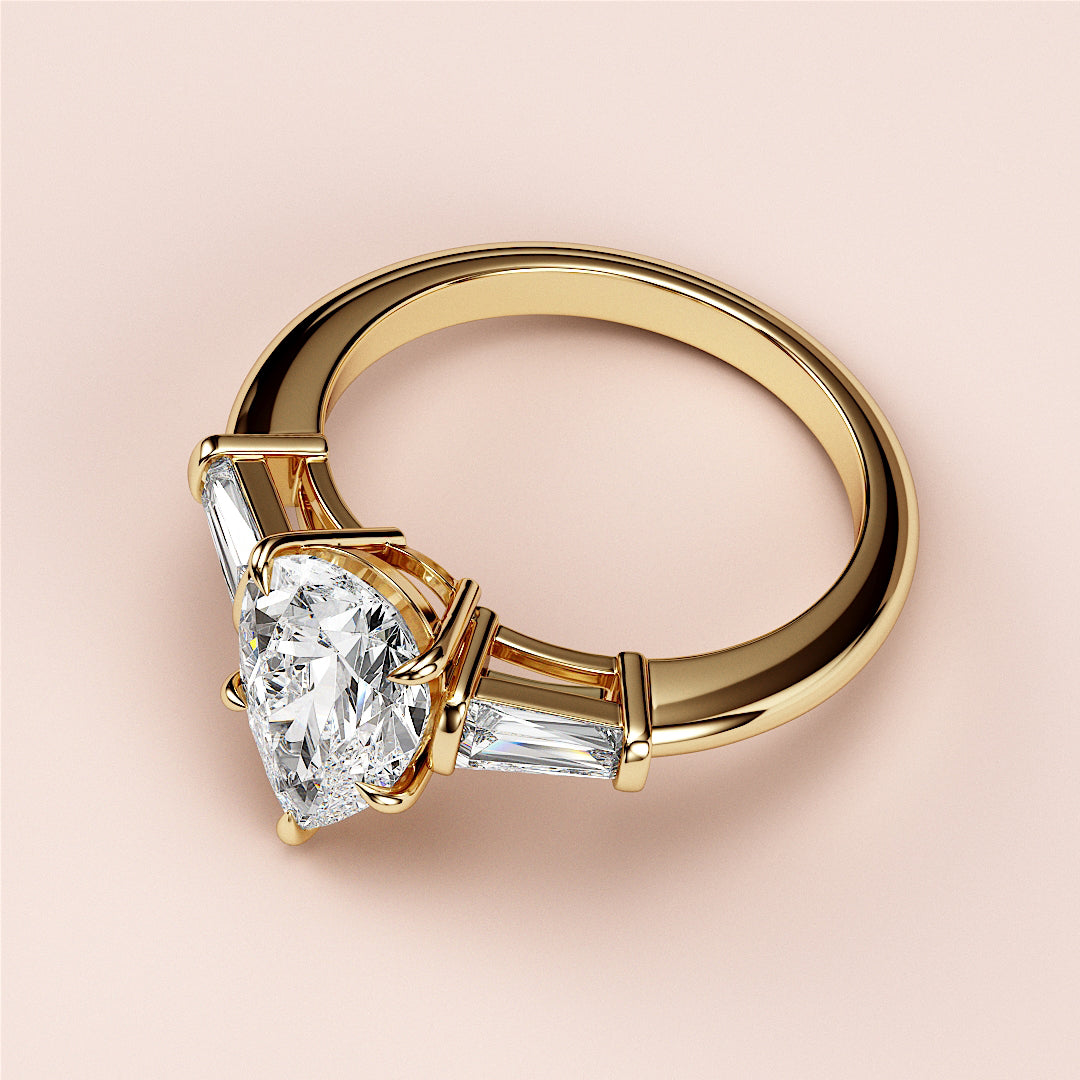 Elegant 14K or 18K yellow gold engagement ring with pear three-stone design and tapered baguettes, ideal for special occasions.|
#14KRecycledYellowGold
#18KRecycledYellowGold
