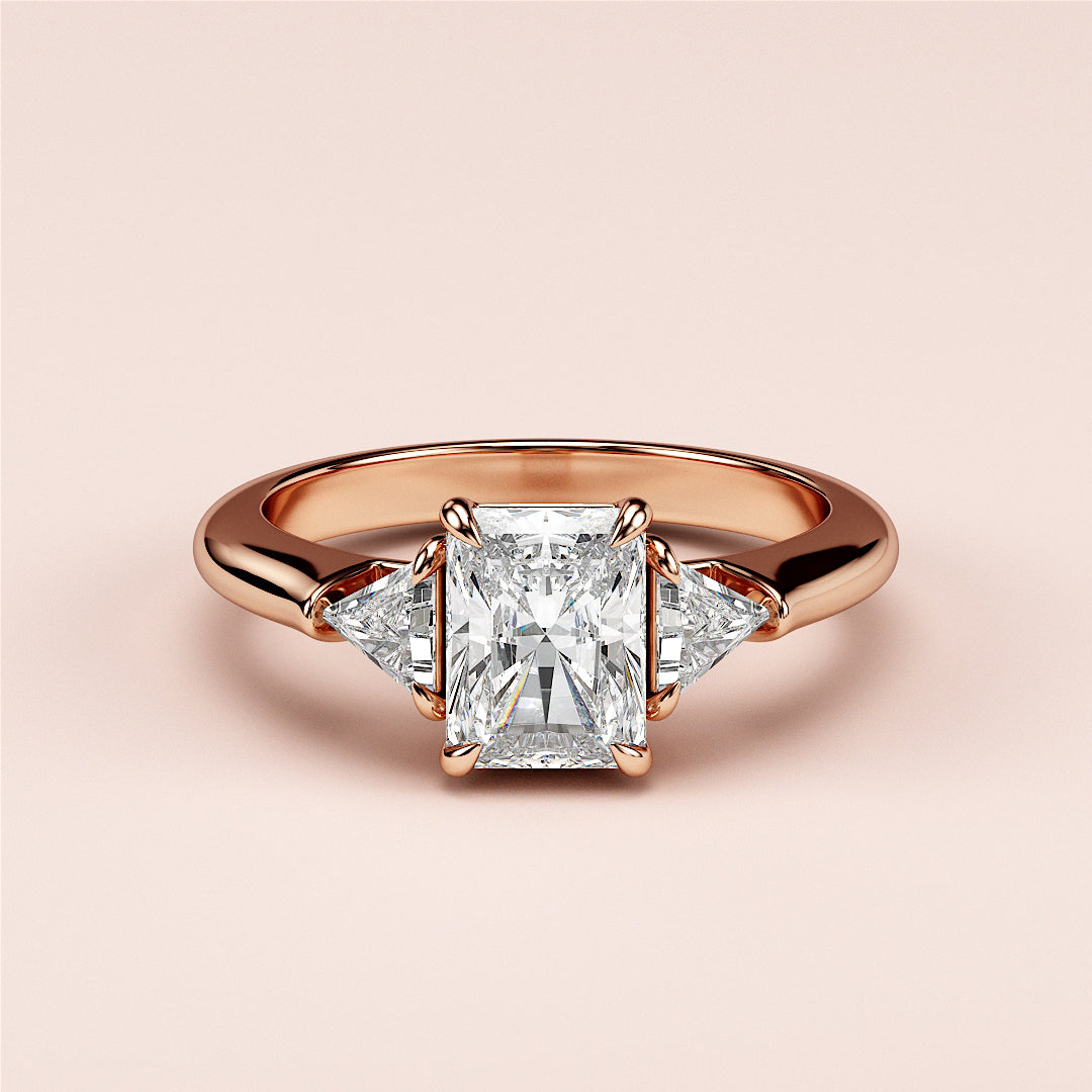Elegant rose gold diamond engagement ring with radiant-cut center and triangular accents, available in 14K, 18K, or platinum.|
#14KRecycledRoseGold
#18KRecycledRoseGold