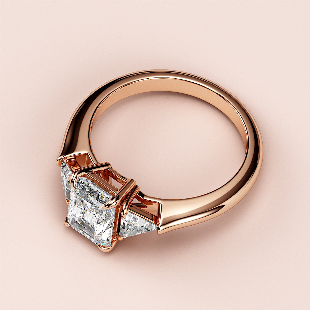 Elegant 14K rose gold engagement ring with a princess-cut diamond and trapezoid side diamonds, perfect for your special moment.|
#14KRecycledRoseGold
#18KRecycledRoseGold