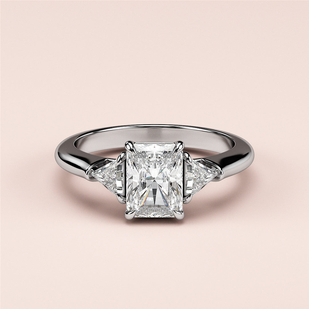 Elegant three-stone diamond engagement ring in 14K white gold, featuring a radiant cut center and trapezoid side diamonds.|
#14KRecycledWhiteGold
#18KRecycledWhiteGold
#Platinum