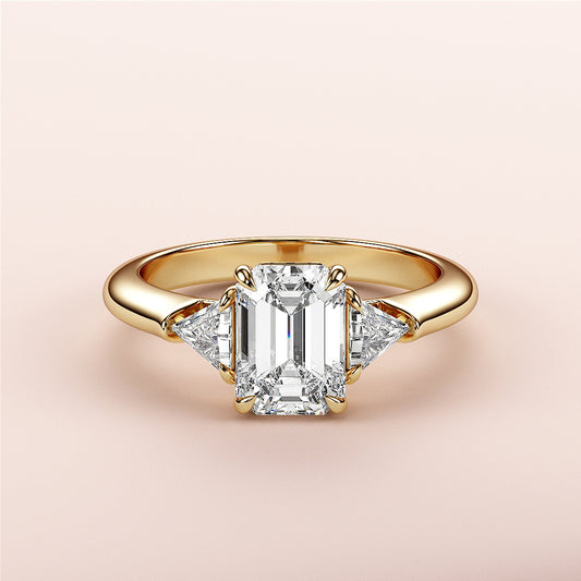 Emerald-cut diamond ring with side trillion diamonds in 14K yellow gold, a stunning engagement ring for timeless elegance.