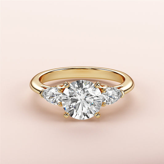 Exquisite 14K/18K gold engagement ring with round diamond center and pear-shaped side stones for a timeless look.