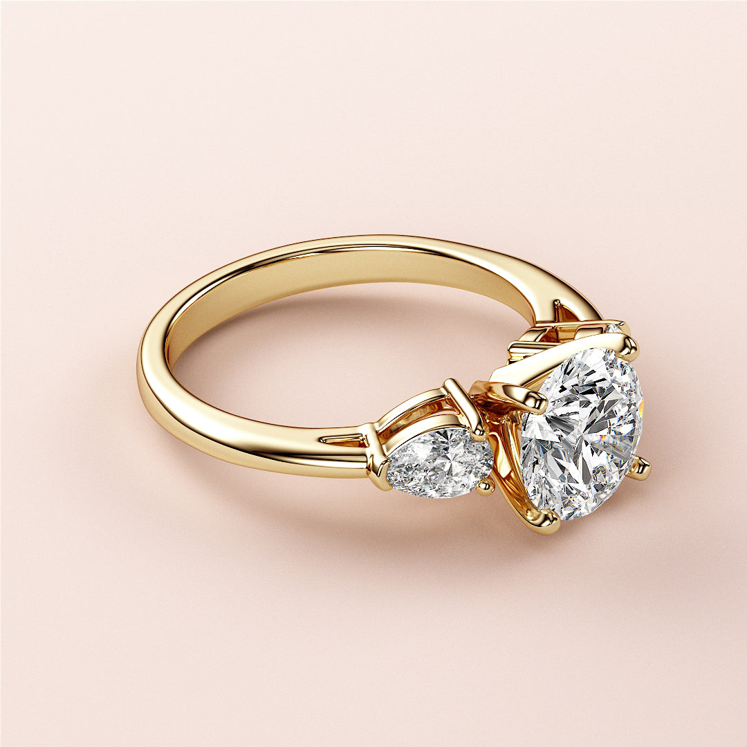 Elegant 14K or 18K gold engagement ring with round brilliant diamond centerpiece and side diamonds, showcasing exquisite craftsmanship.|
#14KRecycledYellowGold
#18KRecycledYellowGold