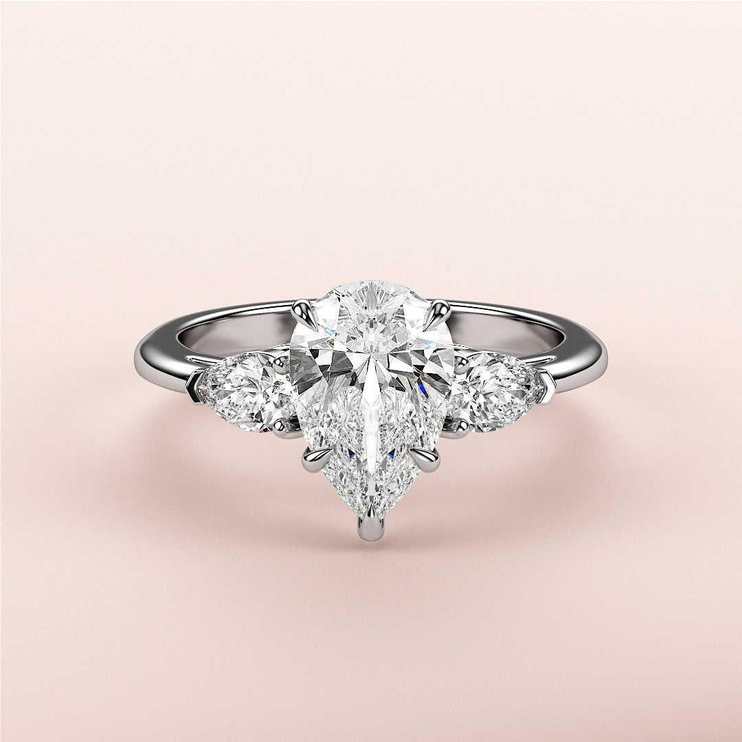 Elegant pear-shaped diamond engagement ring with side stones in 14K or 18K white gold or platinum, showcasing timeless beauty.|
#14KRecycledWhiteGold
#18KRecycledWhiteGold
#Platinum