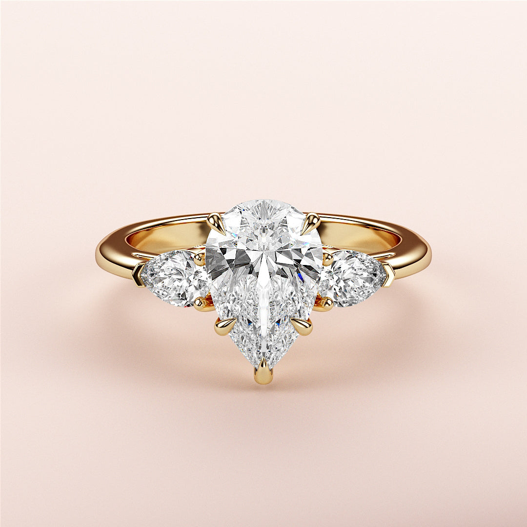 Elegant 14K/18K yellow gold engagement ring with pear-shaped diamond and side stones, perfect for a timeless proposal.|
#14KRecycledYellowGold
#18KRecycledYellowGold