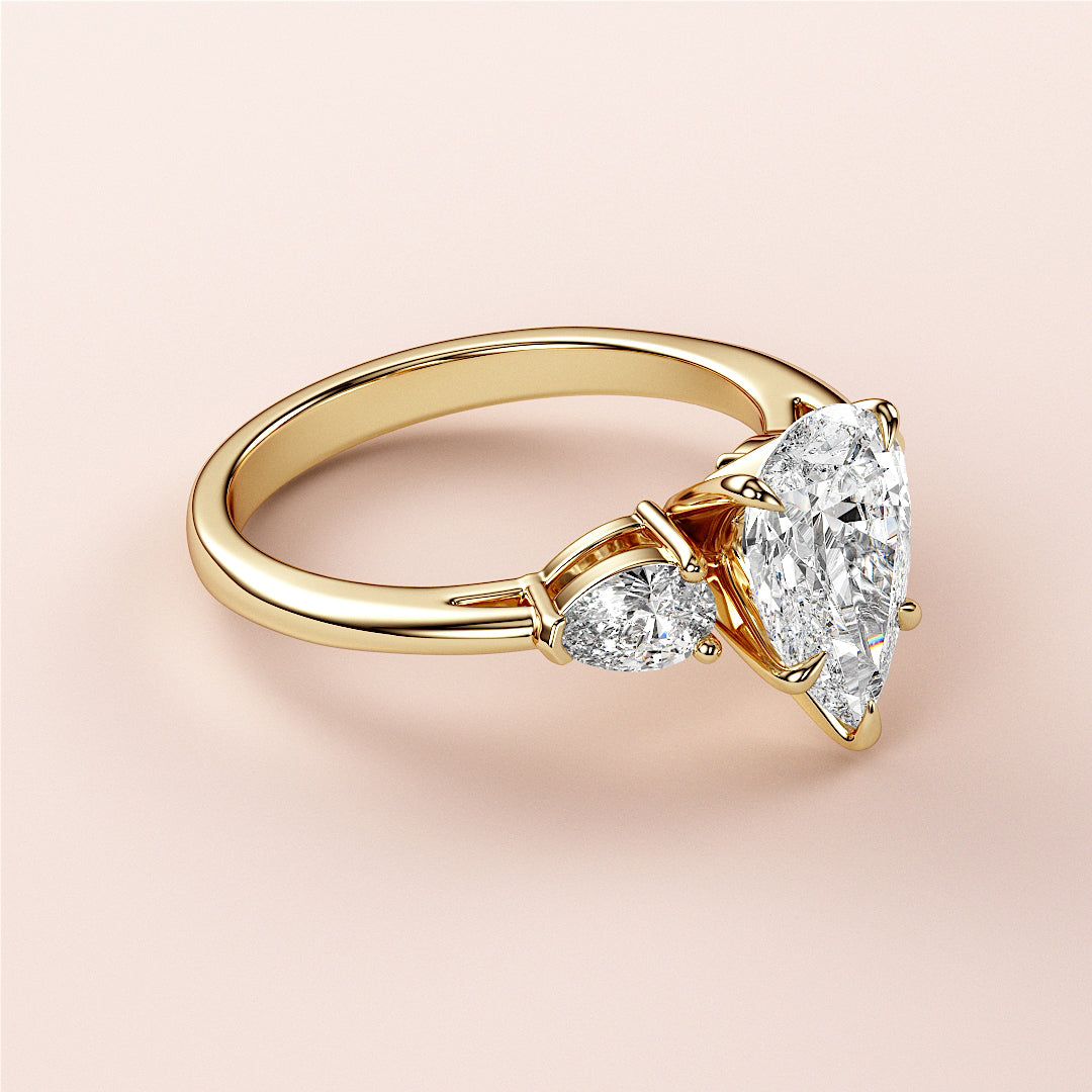 Luxurious 14K yellow gold engagement ring featuring a stunning pear-shaped diamond center stone and two smaller diamonds.|
#14KRecycledYellowGold
#18KRecycledYellowGold