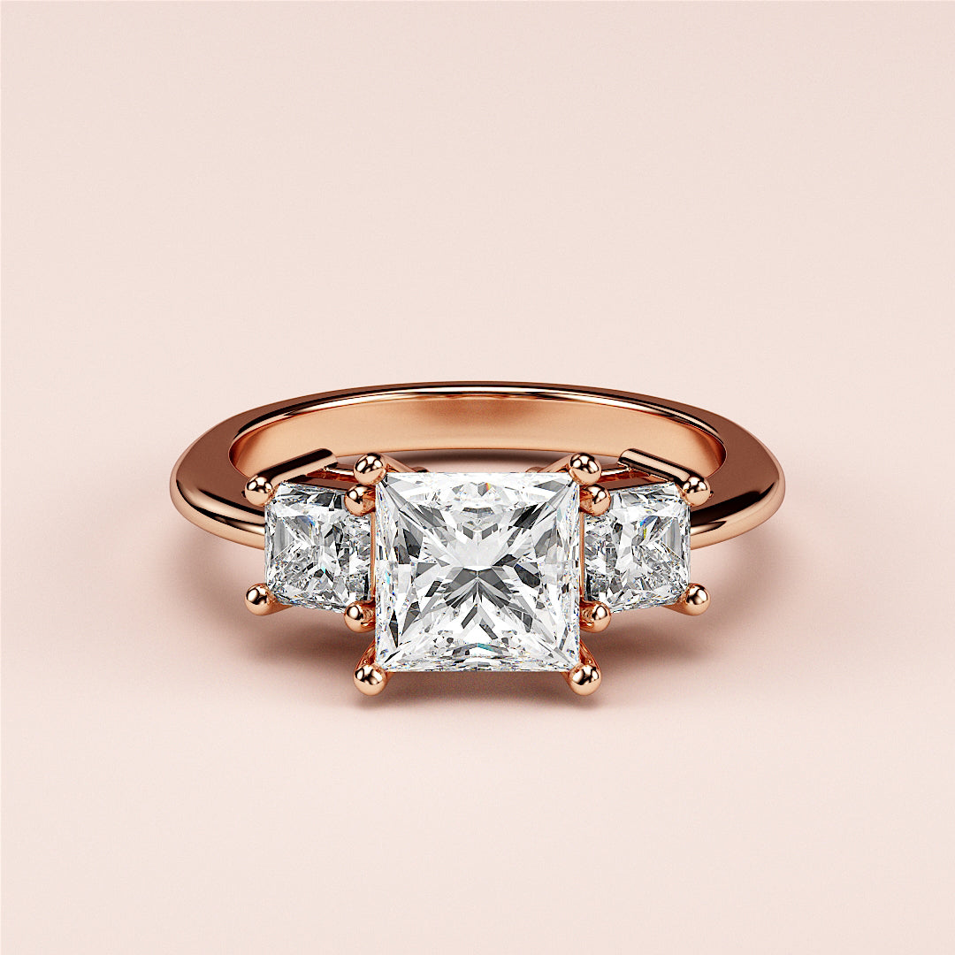 Elegant 14K rose gold three-stone princess engagement ring with a radiant center diamond and dazzling side stones.|
#14KRecycledRoseGold
#18KRecycledRoseGold