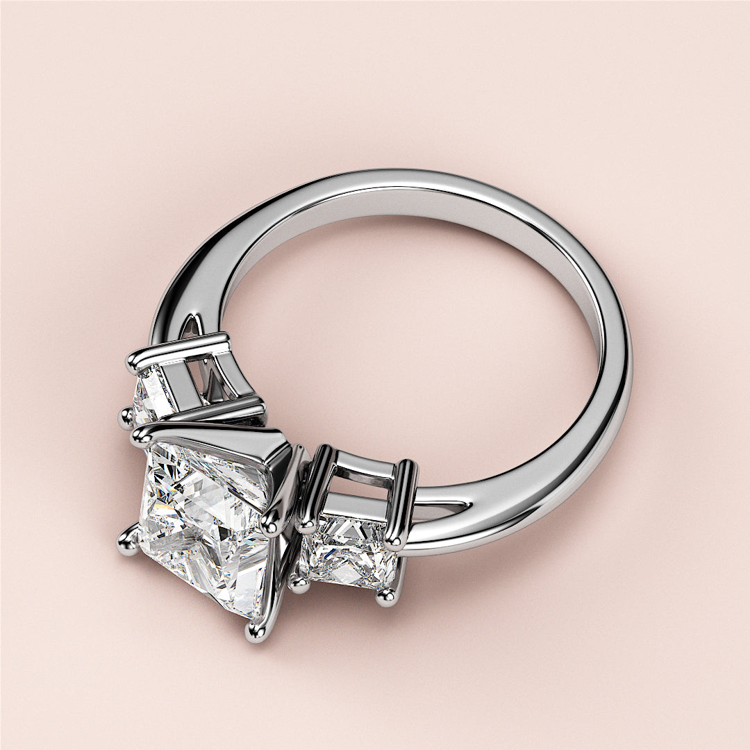 Elegant white gold three-stone princess-cut engagement ring with a central diamond, available in 14K, 18K, and platinum.|
#14KRecycledWhiteGold
#18KRecycledWhiteGold
#Platinum