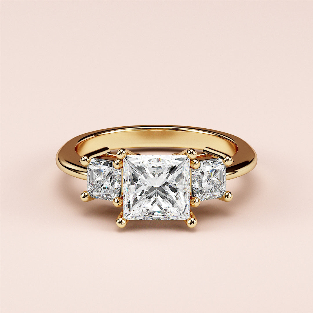 14K yellow gold engagement ring featuring a radiant-cut diamond in a three-stone setting, elegantly worn on a model's finger.|
#14KRecycledYellowGold
#18KRecycledYellowGold