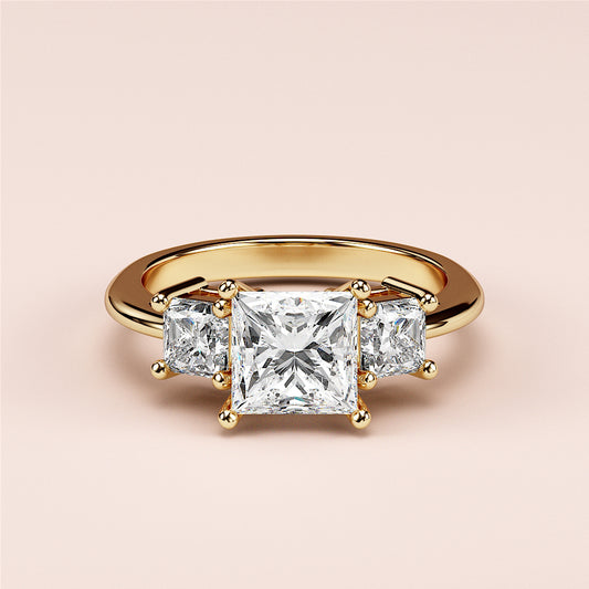 14K yellow gold engagement ring featuring a radiant-cut diamond in a three-stone setting, elegantly worn on a model's finger.