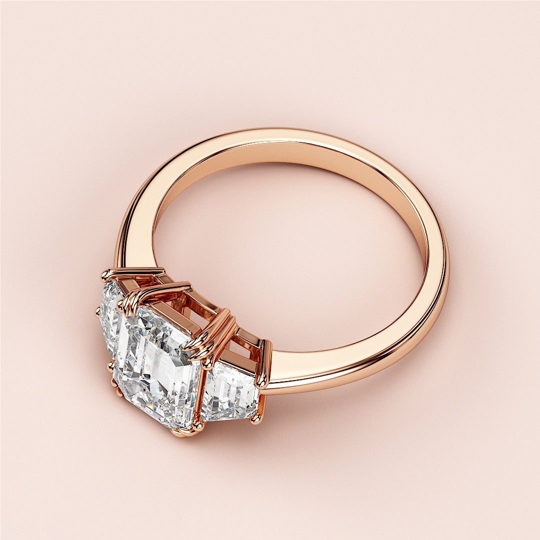 Elegant emerald cut diamond ring in rose gold, featuring a stunning three-stone design, available in 14K, 18K, or platinum.|
#14KRecycledRoseGold
#18KRecycledRoseGold