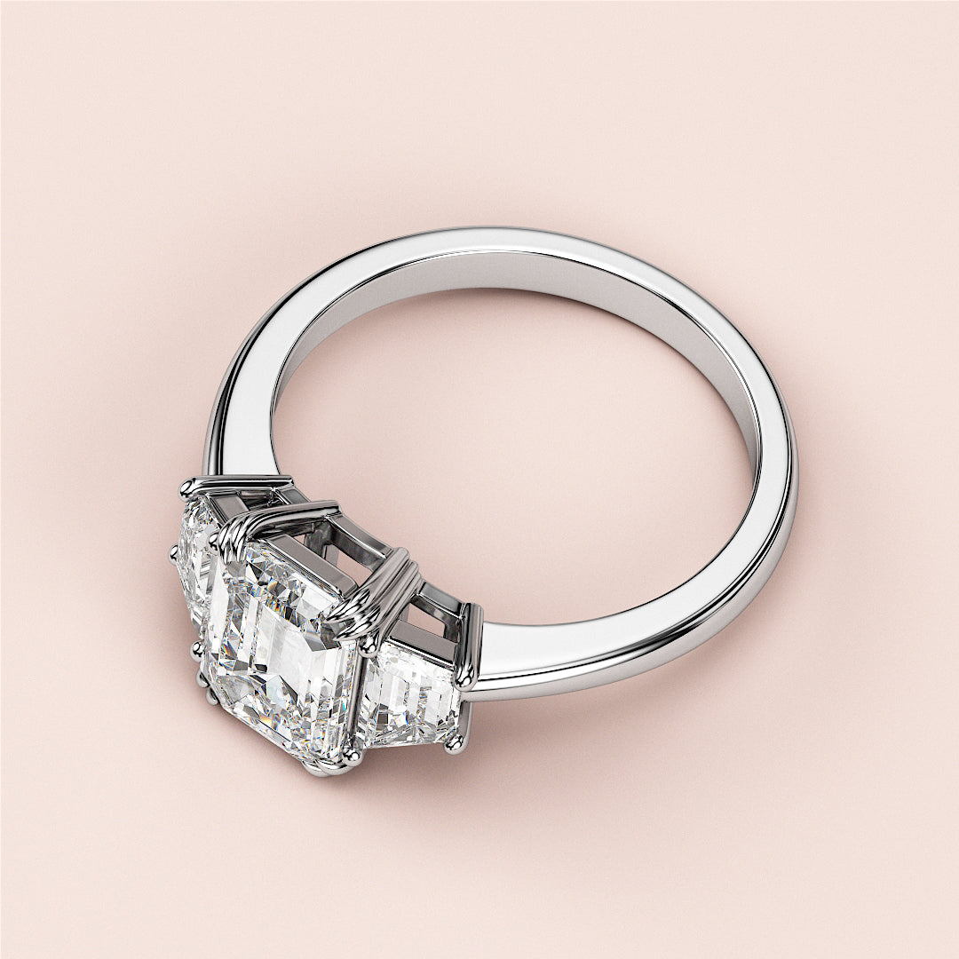 "Classic three-stone emerald-cut diamond engagement ring in 14K, featuring a stunning center diamond and fine craftsmanship."|
#14KRecycledWhiteGold
#18KRecycledWhiteGold
#Platinum