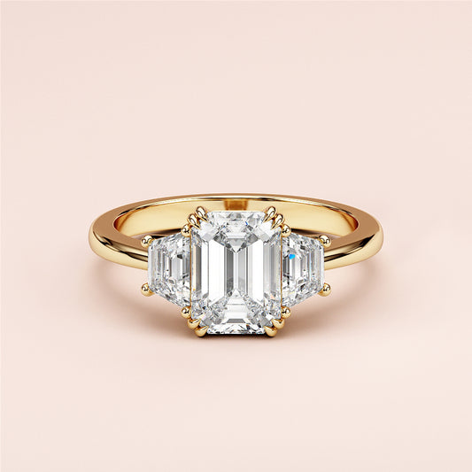 Stunning 14K or 18K gold and platinum engagement ring with emerald-cut diamond and trapezoid side stones.