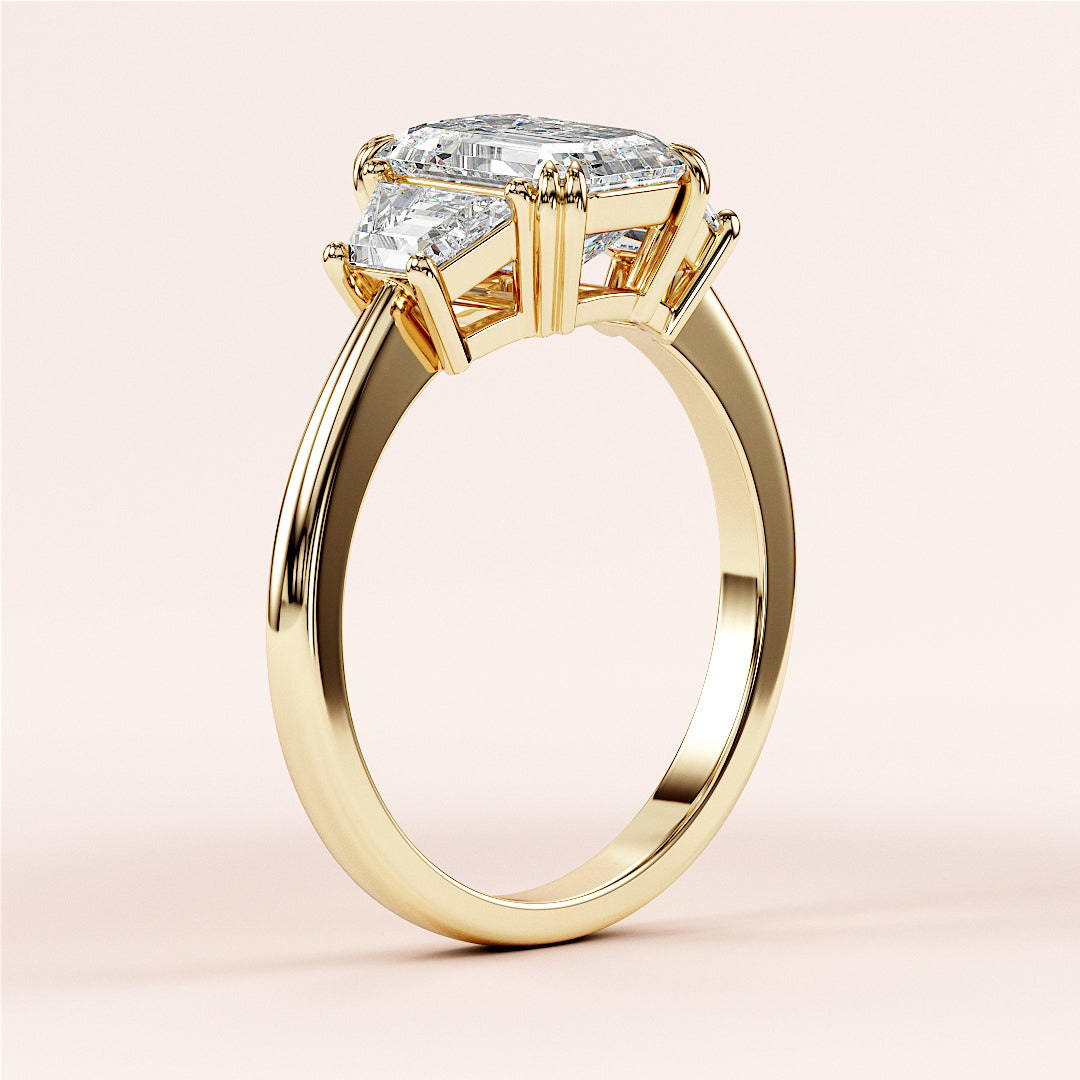 14K yellow gold engagement ring with emerald and three trapezoid stones in a unique prong setting; luxury platinum option available.|
#14KRecycledYellowGold
#18KRecycledYellowGold
