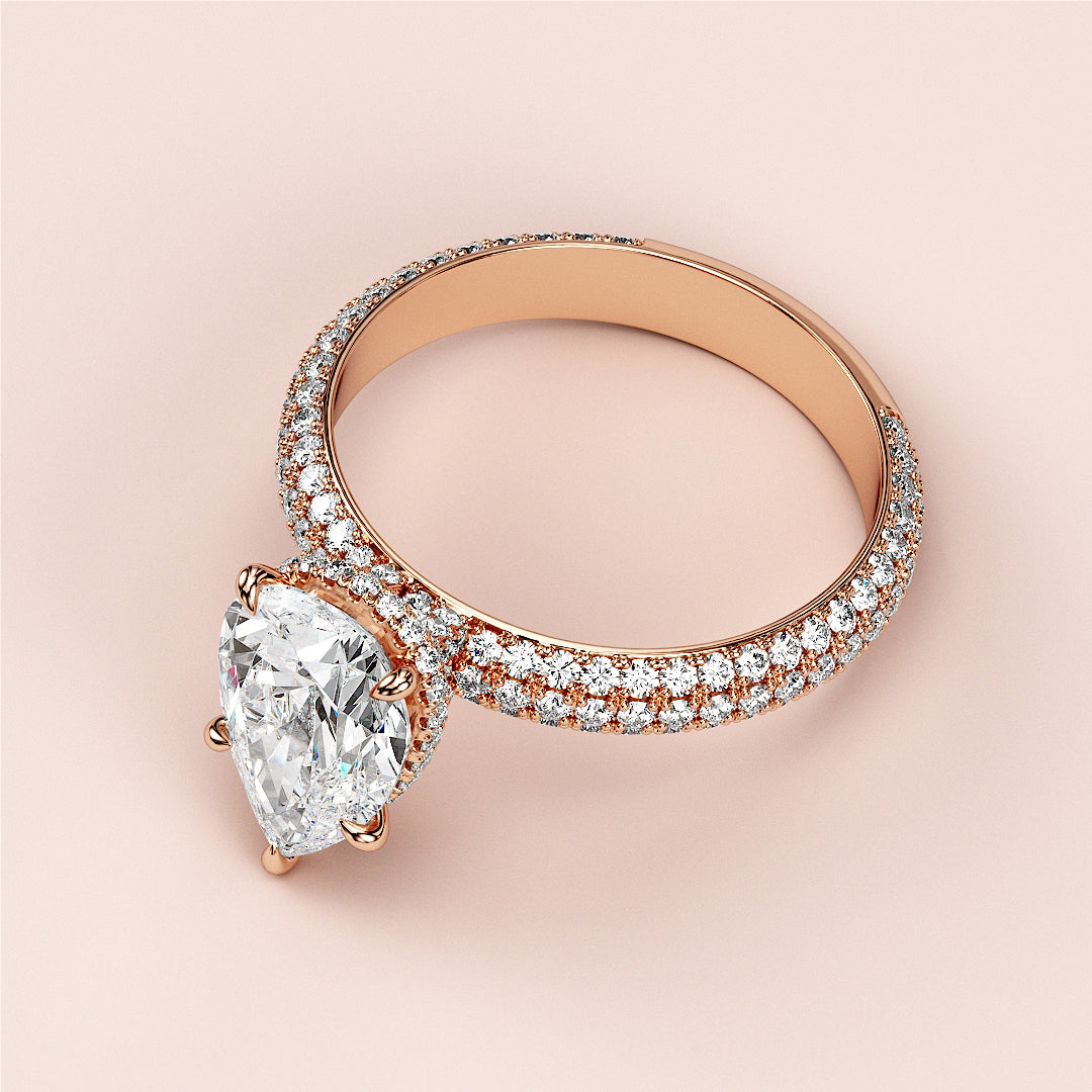 Stunning rose gold 14K pear-shaped diamond engagement ring with halo accents, featuring exquisite craftsmanship and luminous smaller diamonds.|
#14KRecycledRoseGold
#18KRecycledRoseGold
