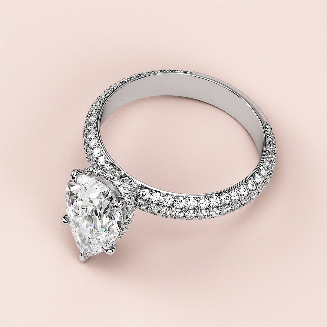 Elegant pear-shaped diamond engagement ring withPave band in 14K gold, featuring hidden halo accents and brilliant-cut diamonds.|
#14KRecycledWhiteGold
#18KRecycledWhiteGold
#Platinum